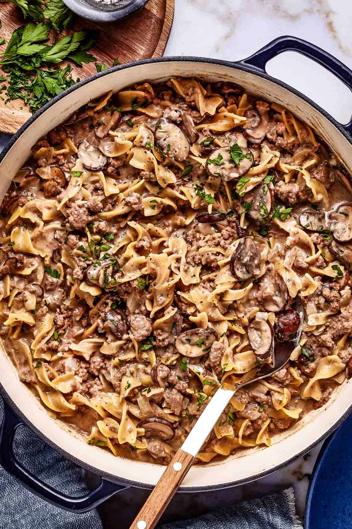 Hamburger stroganoff recipe garnished with parsley in a pot from the top view.