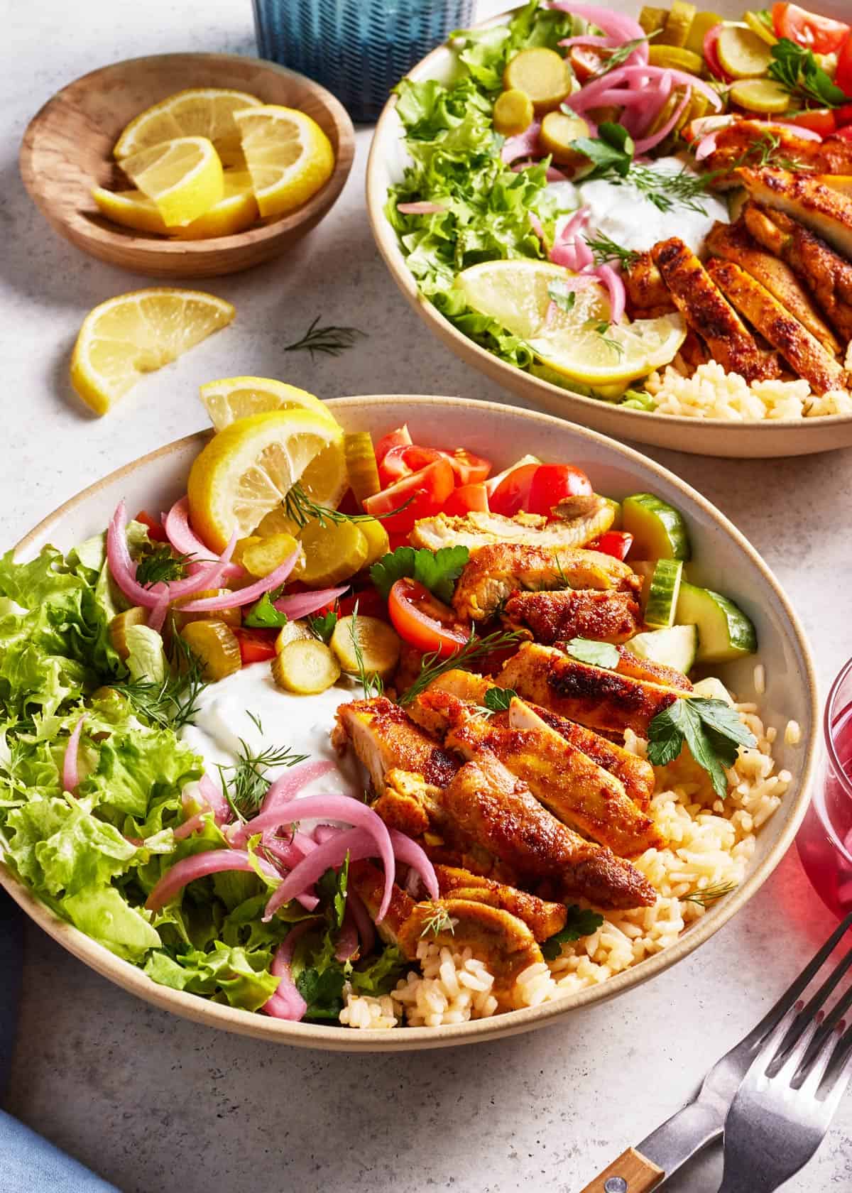 Chicken Shawarma Rice Bowls with fresh lemon slices on the side.