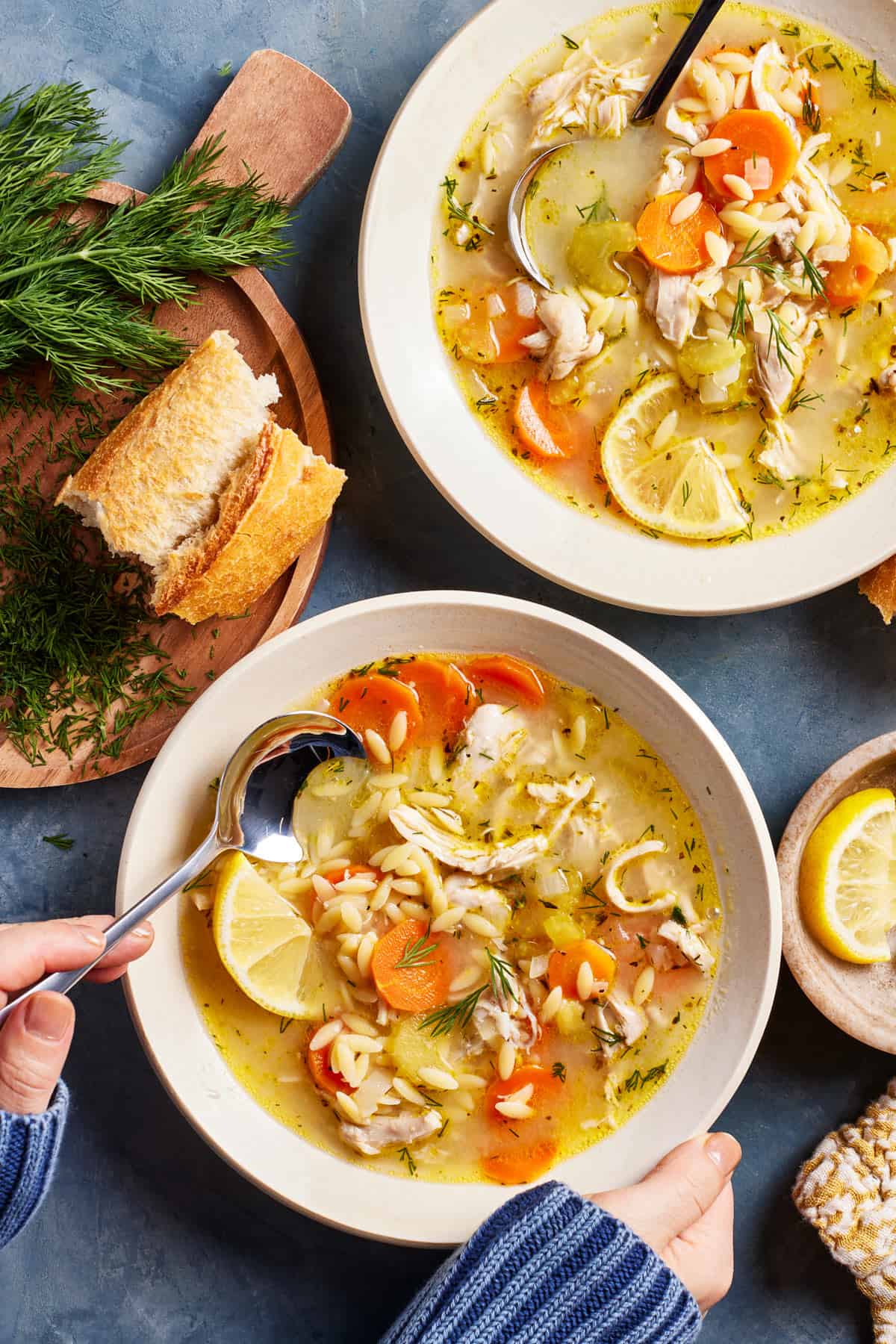 Lemon chicken soup with orzo recipe served in bowls with crusty bread on the side.