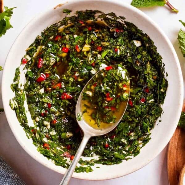 Mint chimichurri in a bowl with a spoon.