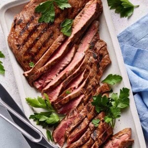Grilled marinated Flank steak sliced on a plate.