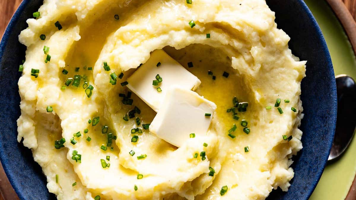 Swirled mashed potatoes garnished with butter and chives.