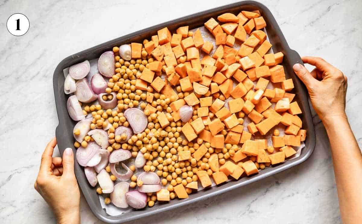 Sweet potatoes, shallots and chickpeas on a sheet pan from the top view.