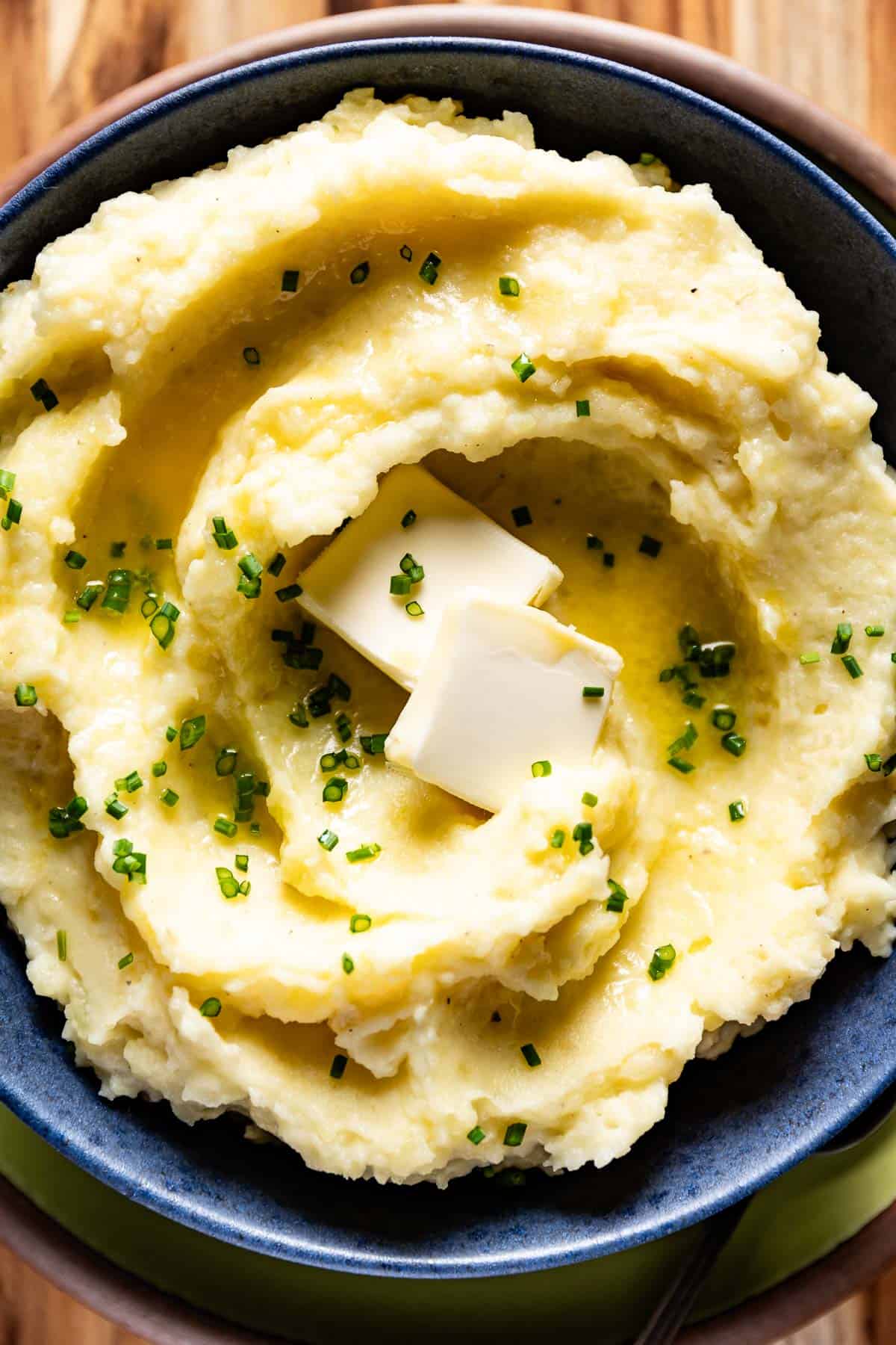 Yukon gold mashed potatoes in a bowl with chives on top.