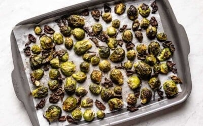 Crispy roasted Brussels sprouts on a sheet pan from the top view.