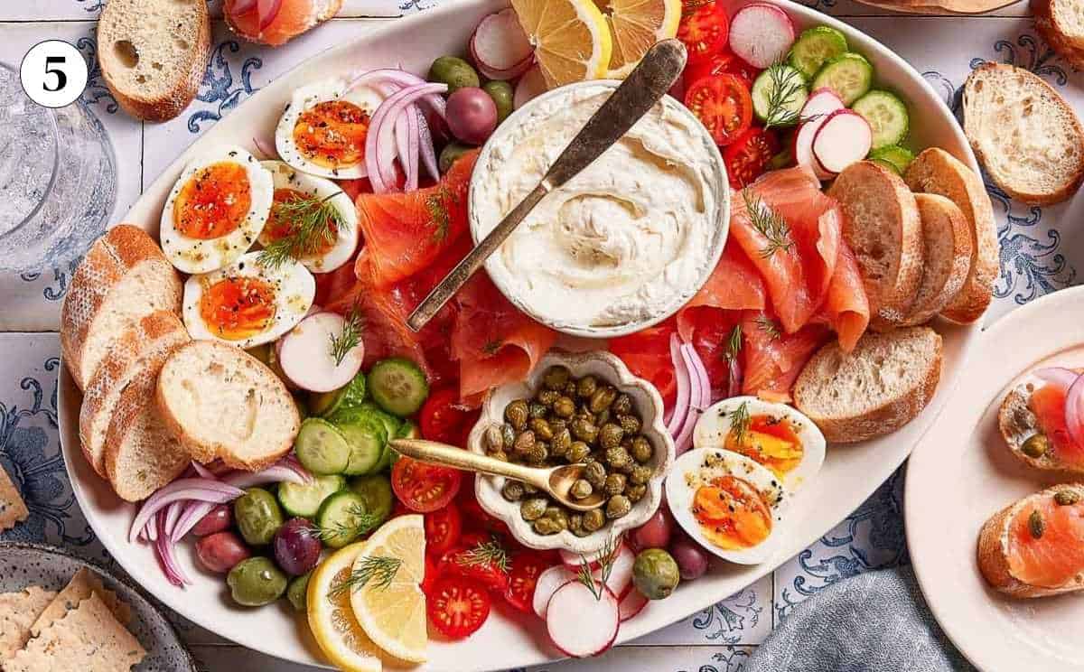 Smoked salmon appetizer platter arranged with vegetables and cheese from the top view.