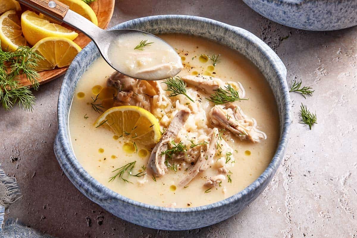 Avgolemono soup garnished with fresh dill from the front view.