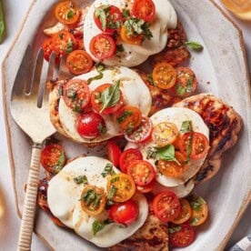 Grilled chicken breasts topped with thick slices of fresh mozzarella, tomatoes, and basil.