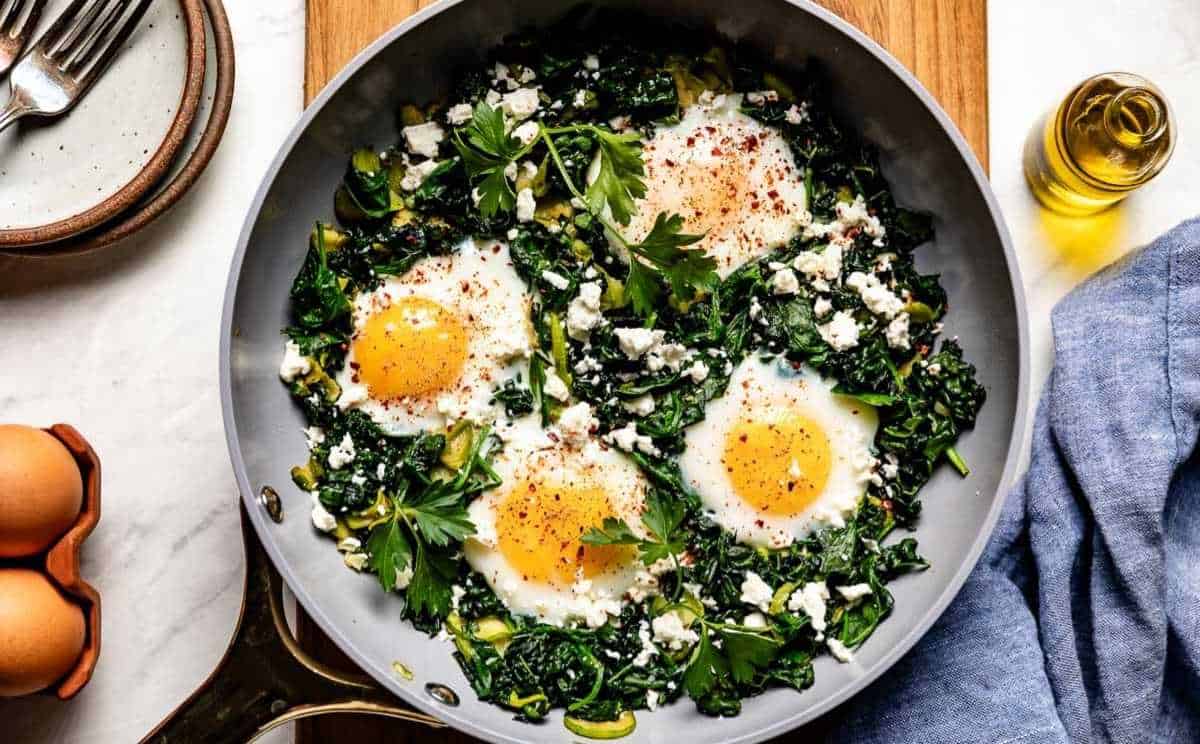 Finished Green Shakshuka garnished with feta cheese, red pepper flakes, and fresh parsley.