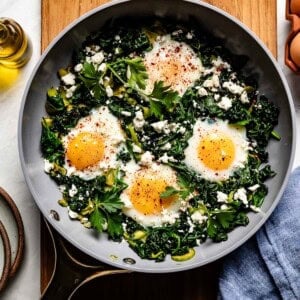 Green shakshuka in a skillet from the top view.