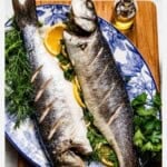 A pin style image with text showing two roasted Mediterranean sea bass on a plate.
